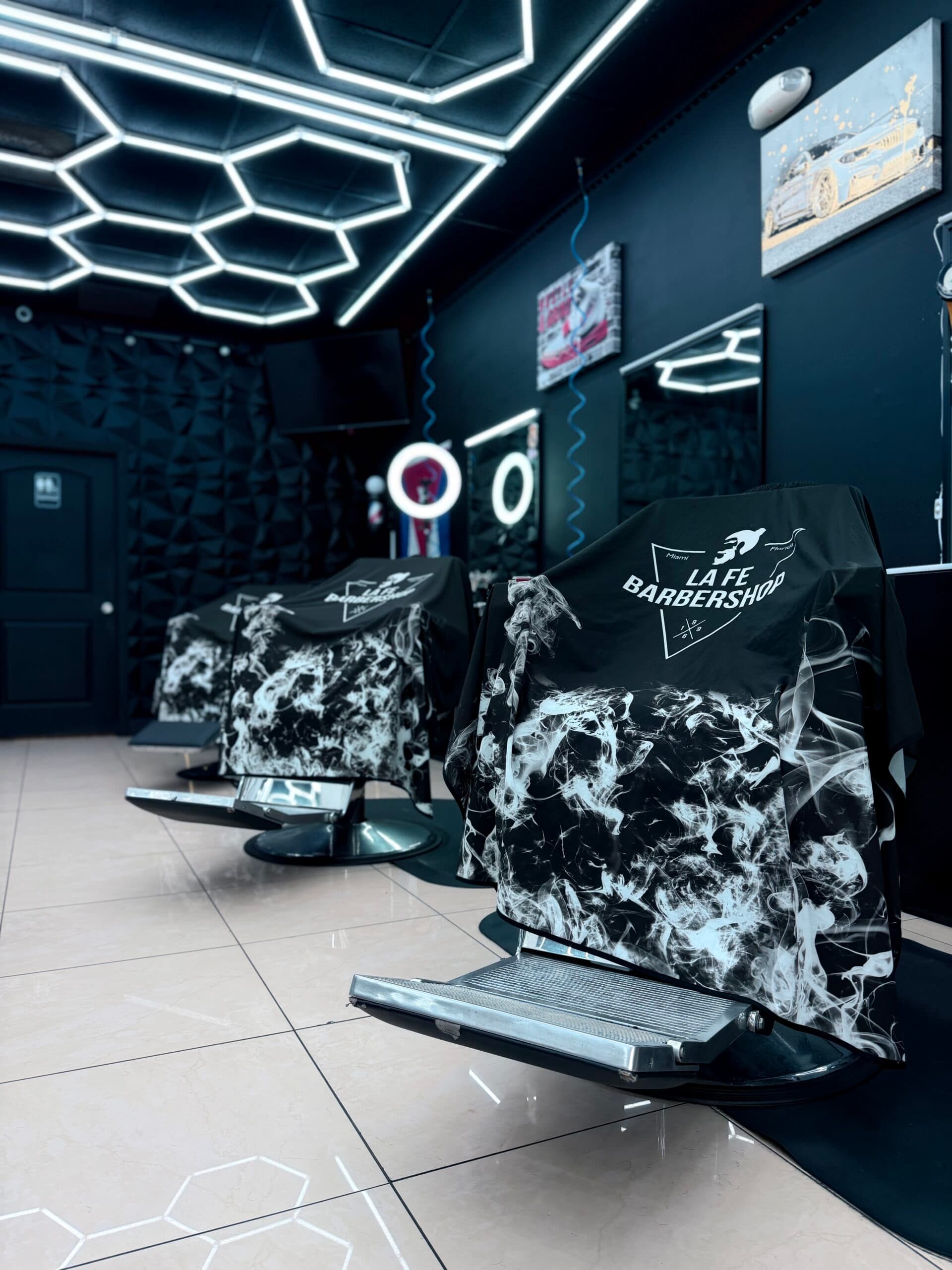 Interior de La Fe Barbershop con iluminación hexagonal y estaciones de corte